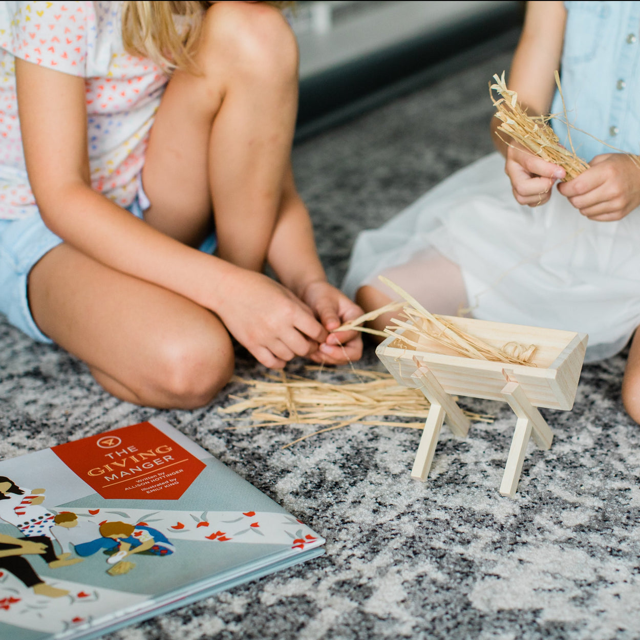 Indoor nativity set for kids with baby Jesus straw and a wooden manger to celebrate advent and giving gifts to other families