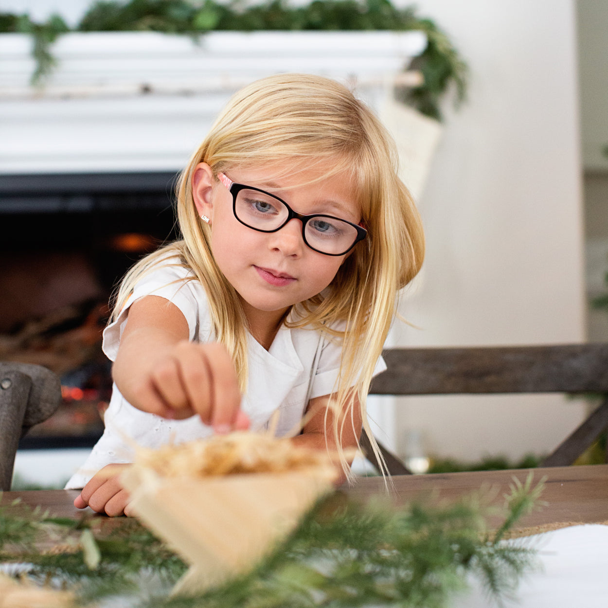 A child using a new Christmas tradition that teaches kindness by filling the manger with straw for baby Jesus this Christmas